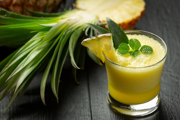 Fresh pineapple and ginger smoothie in a glass with mint leaves — a natural detox drink to reduce bloating and support a flat stomach in the UK.