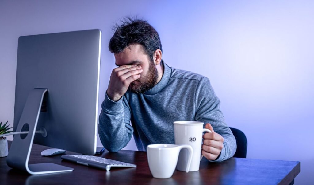 A stressed employee seeking a mental health sick note UK for burnout recovery in 2026 while working from home.
